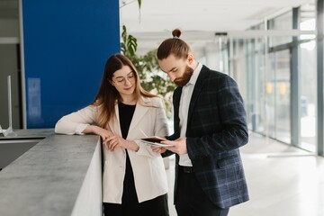 Business professionals discussing project details on digital tablet