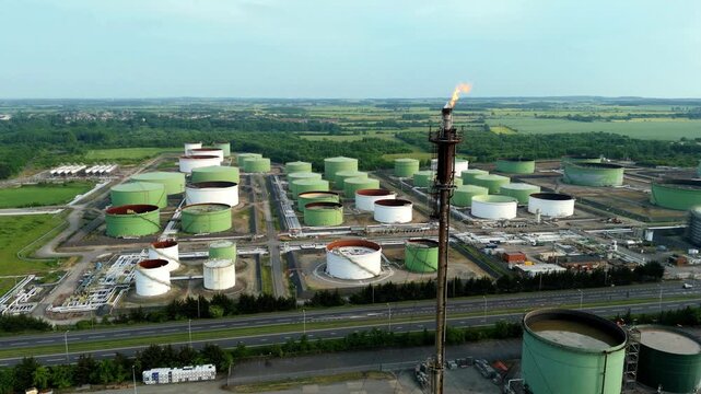 Aerial view of the Humber refinery's array of tanks and a flare stack punctuates the skyline with a burst of flame, Immingham, United Kingdom.