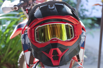 Close up view showing motocross helmet with protective goggles reflecting nature dirt bike handle exhibiting readiness for adventurous ride outdoor setting with focus safety equipment gear © CoreRock