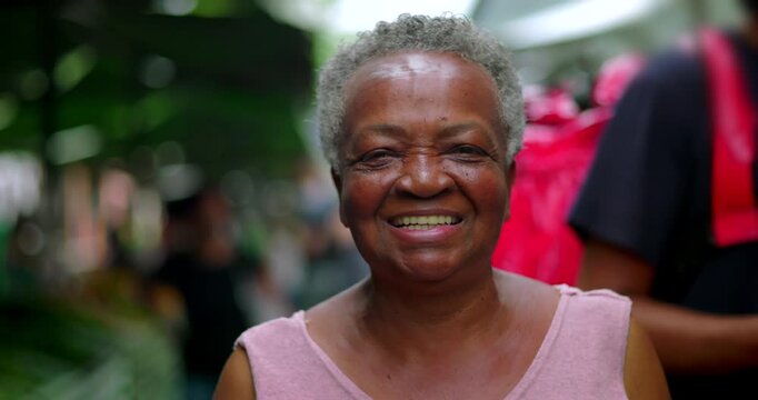 African American elderly woman close up smiling warmly at camera at outdoor market expressing kindness joy openness and positive human connection