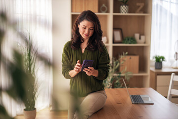 Woman freelancer working from home using smartphone