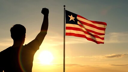Liberian flag waving at sunset with silhouette of man raising fist