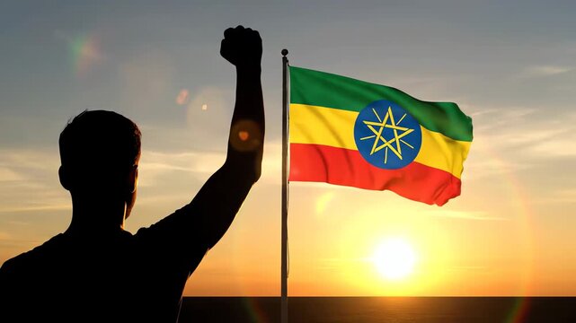 Ethiopian flag waving at sunrise with silhouette of man celebrating