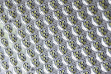 Close up of modern led light panel with textured surface emitting cool glow and showing abstract technology pattern from bright diodes bulb grid in industrial design