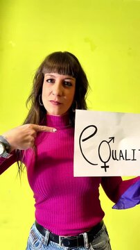 Woman showing equality sign on green background