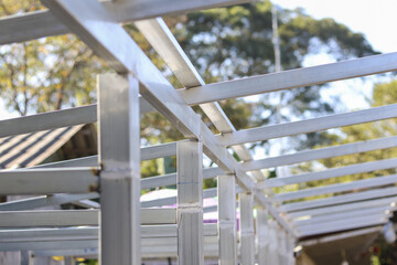 Sturdy silver metal frame construction site with steel roof beam structure blue sky showing tough...