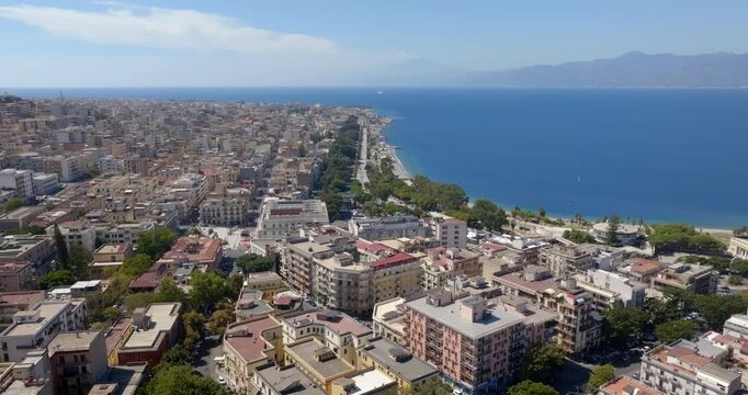 Aerial view of the historic center of Reggio Calabria, in southern Italy. It is a city overlooking the Mediterranean Sea and the Strait of Messina. On the horizon, silhouette of Sicily and Mount Etna.