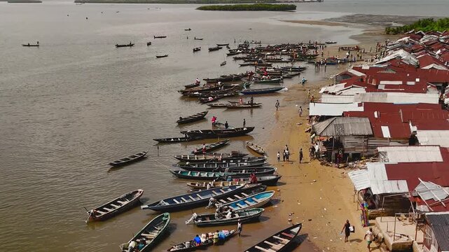 Aerial view of boats dotting the waters near Kaa Waterside, contrasting against the rustic buildings, Kaa, Khana, Rivers State, Nigeria.
