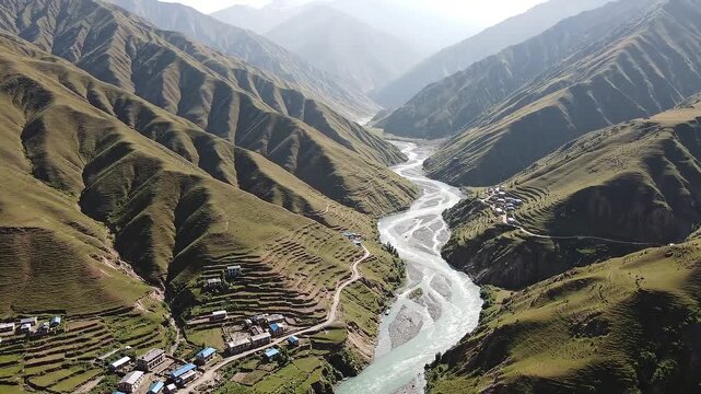 Aerial video of a serene mountain valley with a river flowing through it