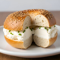Delicious Sesame Seed Bagel with Cream Cheese Spread and Chives on a White Plate