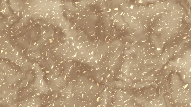 Close-up view of a light brown textured paste with numerous small, light-colored particles suspended within its viscous surface.