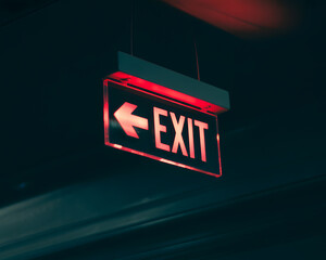 a glowing red EXIT sign suspended in darkness