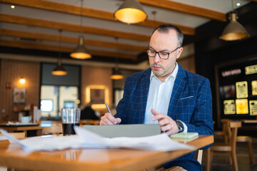 Fototapeta premium Businessman working on tablet in cafe or train station