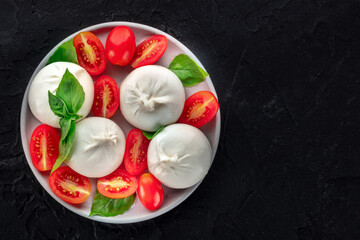 Buffalo Mozzarella, fresh cherry tomatoes, and basil leaves, Italian Caprese salad, overhead flat lay shot with copy space