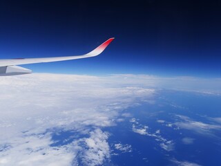 空を飛ぶ飛行機の景色と飛行機の翼 © Seven