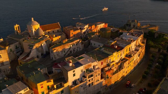 Aerial view circling sunlit houses in the Procida village, sunny evening in Italy
