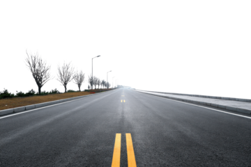 Asphalt road with yellow double lines leading towards a bright horizon lined with trees highway street