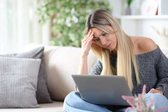 Worried woman checking online content on personal computer