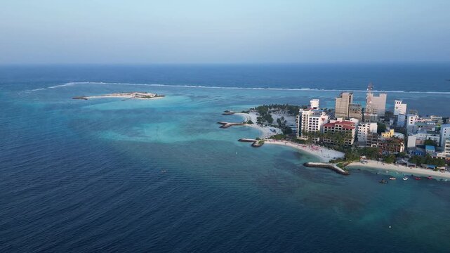 Maafushi, Maldives: Aerial drone footage of Maafushi, a local island in Kaafu Atoll of Maldives. Taken with tilt up and downward motion showing another small island in the background and blue ocean