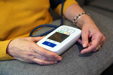 High blood pressure. Elderly woman's hands taking her blood pressure.