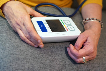 Blood pressure problems in older people. Hands of an older woman taking her blood pressure.