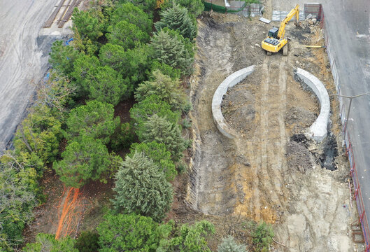 Aerial view of a construction site where a yellow excavator works amidst the dirt and emerging structure, Halkali Merkez, Kucukcekmece, Turkey.