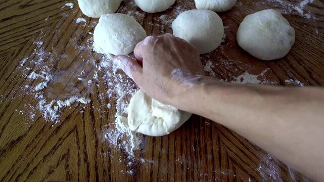 Making homemade bread. Dividing the dough into portions. Kneading the dough into small balls. Home baking. Traditional recipes. Making Caucasian cheese pie &mdash; Adjarian khachapuri. Step by step.