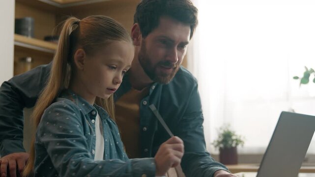 Happy Caucasian family at home man at kitchen little daughter kid child girl write homework problem education father help e-learning laptop helping with difficult question explain support assistance