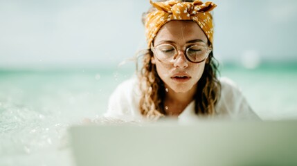 A young woman immersed in her work, typing on a laptop while surrounded by the calm waters of the ocean, showcasing the balance between productivity and nature.
