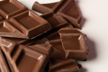 Close up of milk chocolate pieces with glossy surface