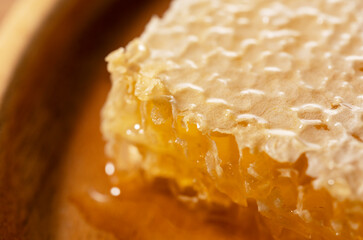 Macro Shot of Golden Organic Honeycomb on a Wooden Plate - Pure Raw Honey Texture