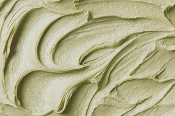 Smooth green cosmetic cream background with textured wavy pattern. Natural skin care beauty product. Facial mask or body lotion concept.