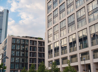Fototapeta premium Frankfurt, Germany - May 15, 2023: Bottom view of modern skyscrapers in business district in evening light in Frankfurt
