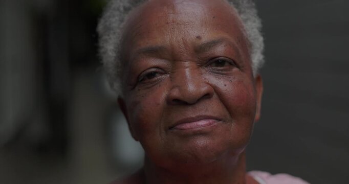 African American elderly woman outdoors close up looking at camera with calm reflective expression conveying dignity resilience life experience wisdom and quiet inner strength