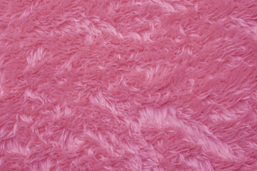 Detailed description of soft fluffy pink plush textile fabric background with cozy fur texture