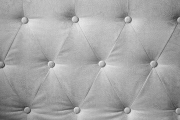 Fototapeta premium Elegant silver gray tufted textile background with decorative buttons forming a diamond pattern