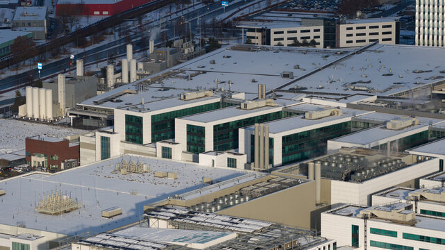 Aerial view of the sprawling ASML complex dusted with snow, its modern architecture contrasting against the wintry landscape, Veldhoven, Noord-Brabant, Netherlands.