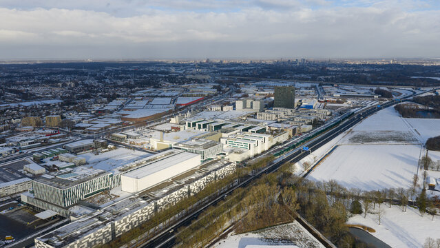 Aerial view of the ASML campus dusted with snow, its modern architecture stark against the winter landscape, Veldhoven, Noord-Brabant, Netherlands.