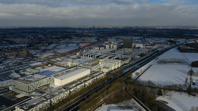 Aerial view of snow-dusted ASML buildings contrasting against the clear blue sky, Veldhoven, Noord-Brabant, Netherlands.