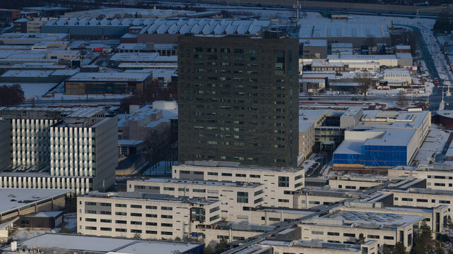 Aerial view of modern architecture contrasting with a dusting of snow covering rooftops and streets, Veldhoven, Noord-Brabant, Netherlands.