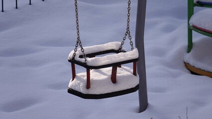 Huśtawka pokryta śniegiem na placu zabaw © tomo81