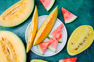 Assortment of ripe cantaloupe and watermelon slices arranged on a table
