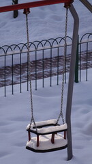 Huśtawka pokryta śniegiem na placu zabaw © tomo81
