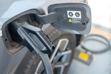 Charging EV car with DC fast charge plugging socket. New energy vehicle with modern technology, close-up. 