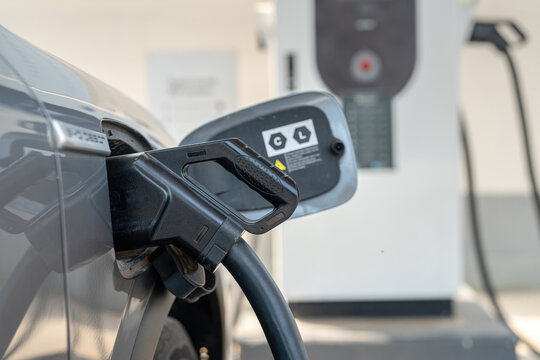 Charging EV car with DC fast charge plugging socket. New energy vehicle with modern technology, close-up. 