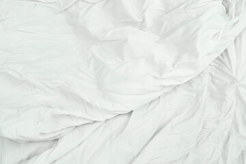 A close-up of white linen, showing the detailed texture and elegant folds of the fabric, its wavy...