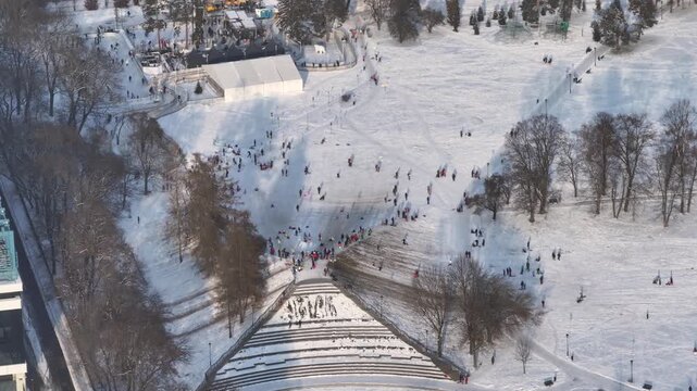 Snow-covered park attracts visitors engaging in diverse winter activities