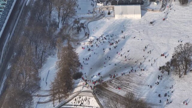 Winter activities in a snow-covered park with people enjoying the outdoors