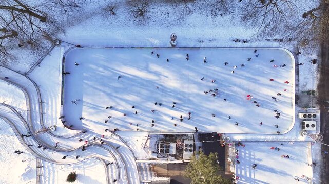 Ice skating on a frozen pond with people participating in winter activities