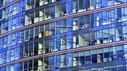 Obraz premium A modern tall building made of steel and glass, housing offices and financial institutions. Glass wall on the facade of the building.